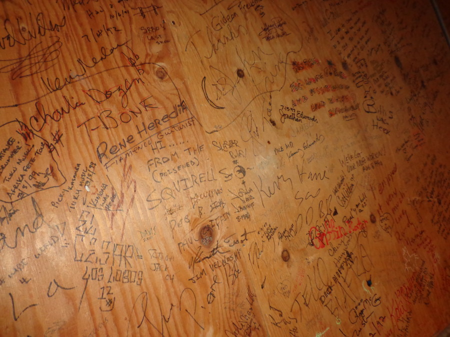 Past performers sign the greenroom wall.